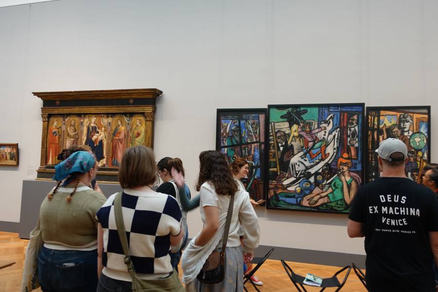 Students discuss paintings during a museum tour.
