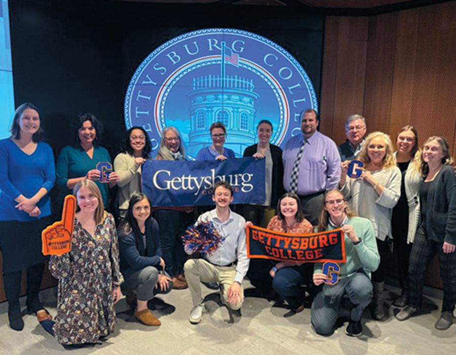 A photo of a group of students posing together and holding Gettsbrg College banners