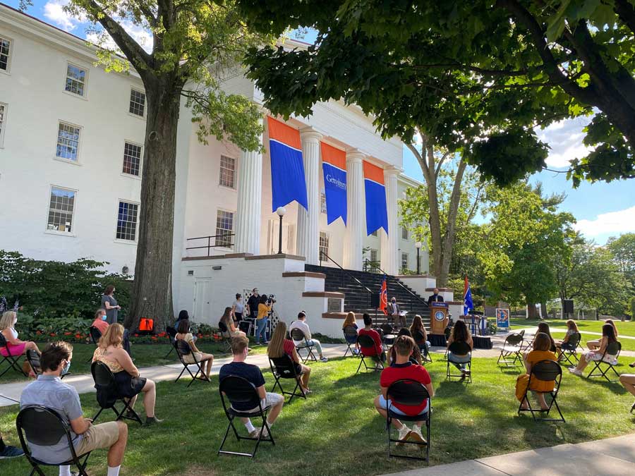 Students sitting on the lawn in front of Penn Hall during a speech